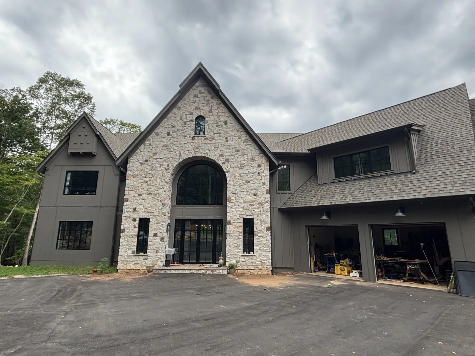 Stone and cedar craftsman exterior with an arched feature window.
